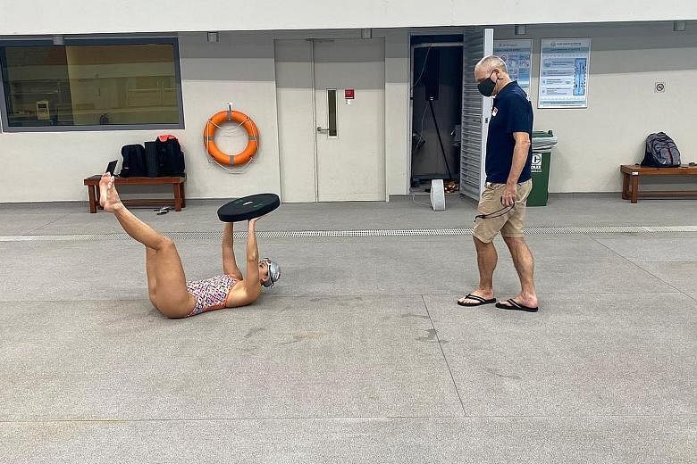 National swimming coach Stephan Widmer, his mask on, keeps the appropriate social distance as he monitors the progress of Amanda Lim at the OCBC Aquatic Centre.