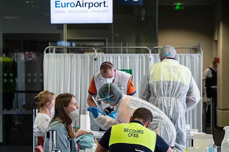 A French healthcare worker collecting a swab sample from a passenger arriving from Istanbul at an airport in Saint-Louis in north-eastern France on Tuesday. PHOTO: AGENCE FRANCE-PRESSE