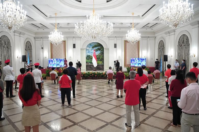 President Halimah Yacob (seated in front row) and Prime Minister Lee Hsien Loong (seated on her right) with the Istana staff during the National Day observance ceremony hosted by the President's Office at the Istana yesterday. They were joined by nea