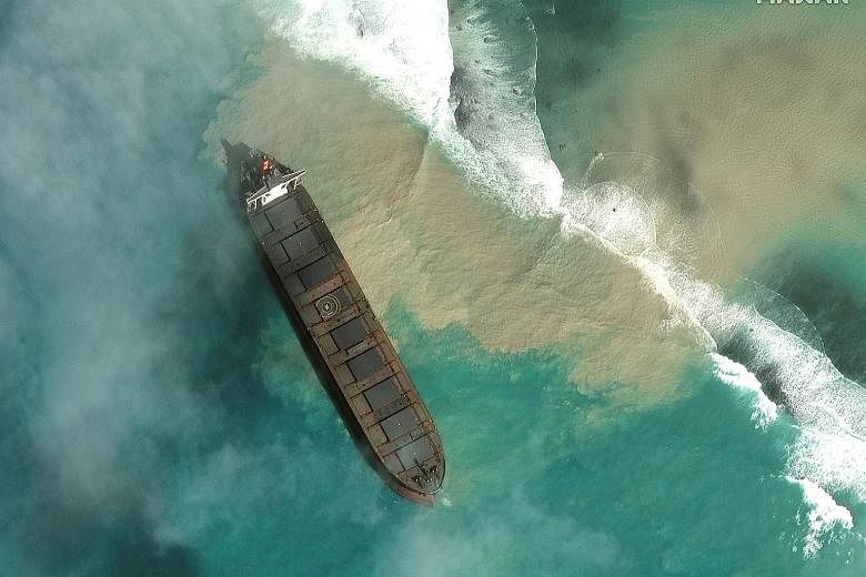 People in south-east Mauritius on Thursday looking at the stricken MV Wakashio, which is Japanese-owned but Panamanian-flagged. High waves have hampered efforts by the ship's operator, Mitsui O.S.K. Lines, to contain the fuel spill, and bad weather c