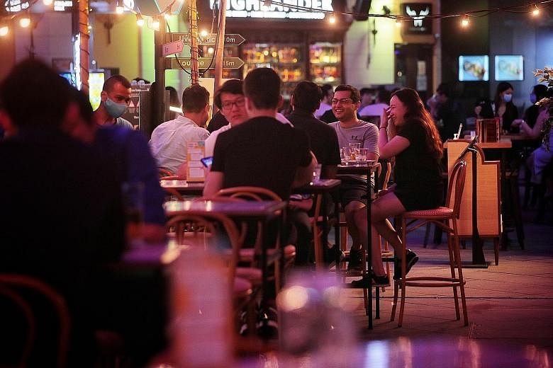 Restrictions on group sizes and live entertainment and a 10.30pm cut-off time for alcohol sales pose significant challenges, industry players say. Above: At Clarke Quay, temperature screening stations are positioned at four key entrances. Right: Abou