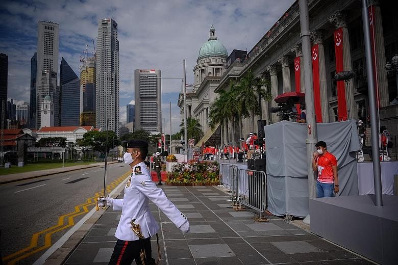Parade commander Nicholas Ong practising at the National Day Parade rehearsal at the Padang on July 26. Before the parade, Lieutenant-Colonel Ong tapes a small strip of cosmetic tape to the apex of his nose, to keep his white face mask in place while