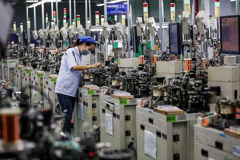 A worker making inductors for export in China's Jiangsu province last month. Industrial production growth is forecast to have picked up and retail sales may have stopped shrinking last month, in numbers due this Friday. PHOTO: AGENCE FRANCE-PRESSE