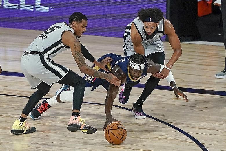 Pelicans guard Jrue Holiday diving for a loose ball between Spurs guards Dejounte Murray and Derrick White during their NBA game on Sunday. San Antonio won 122-113 to knock New Orleans out of play-off contention. There are two spots left with the Spu