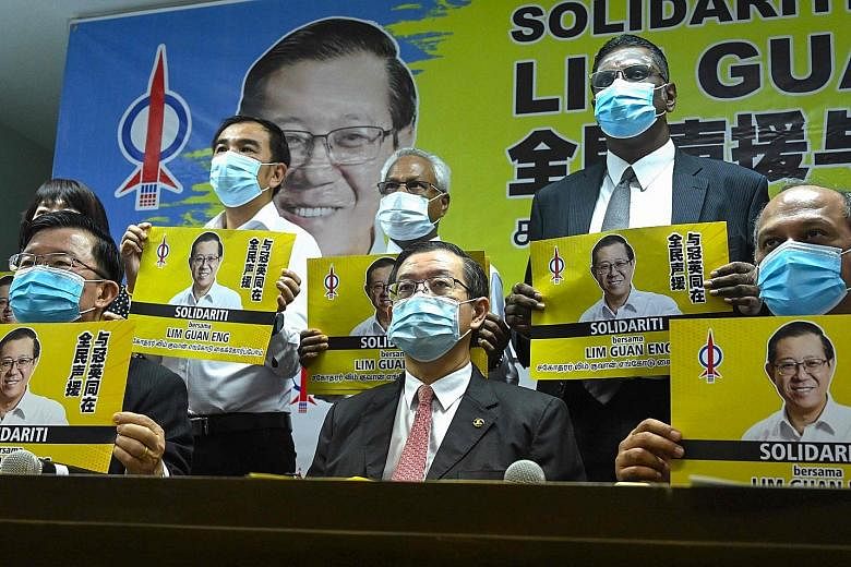 Malaysia's former finance minister Lim Guan Eng (centre) with his supporters during a meeting with the press in Penang yesterday, after being charged with receiving a bribe in connection with an undersea tunnel project when he was chief minister of t