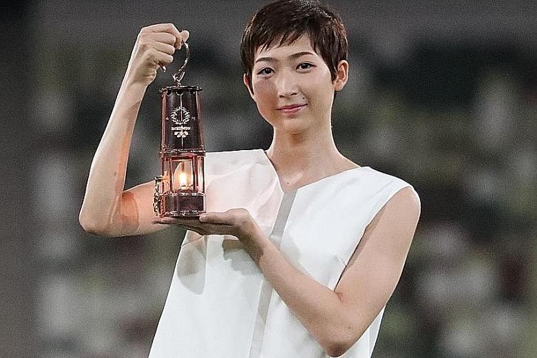 Japanese swimming star Rikako Ikee with the lantern containing the flame, during the unveiling of the "One Step Forward +1 Message" at the Tokyo Olympic Stadium on July 23 that marked a year to the postponed Games.