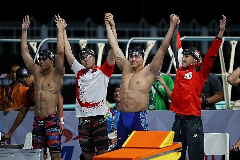 Olympic champion Joseph Schooling (second from right) and Quah Zheng Wen (extreme right) can continue to train "unhindered" for the Tokyo Games after Mindef granted the pair extensions to their national service deferments.