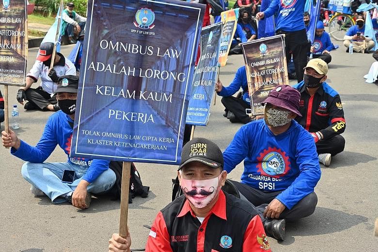 Indonesian workers protesting outside the presidential palace in Jakarta on July 22 against the Bill on job creation they believe will deprive workers of their rights. The Bill will allow employers to hire and fire with lower severance pay and benefi