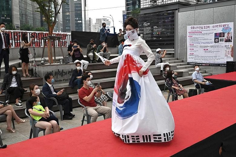 A model wearing a face mask posing on the catwalk during a mask fashion show at the Gangnam district in Seoul yesterday. The audience members were kept a safe distance apart from each other. South Korea is battling a second wave of the coronavirus. P
