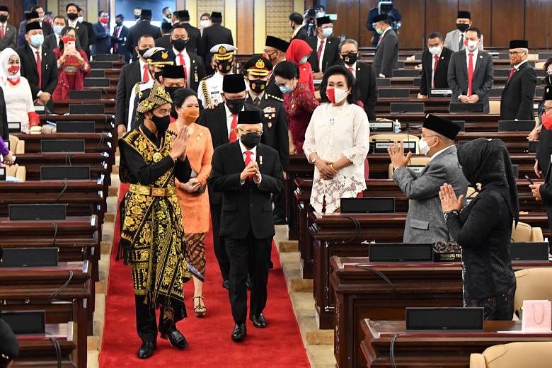 Indonesian President Joko Widodo - dressed in a traditional outfit from East Nusa Tenggara - and Vice-President Ma'ruf Amin greeting assembly and House members before Mr Joko's state of the union address in Parliament in Jakarta yesterday. PHOTO: AGE