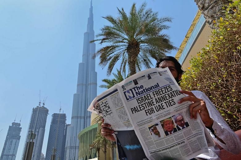 DUBAI A man reading the United Arab Emirates-based newspaper The National in Dubai yesterday, with a report on its front page on what the UAE describes as an agreement that will stop further Israeli annexation of Palestinian territories. 