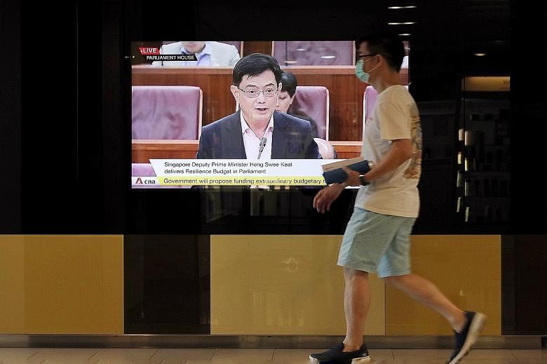 Deputy Prime Minister Heng Swee Keat seen on television announcing the Resilience Budget on March 26. This year's four Budgets together commit close to $100 billion - or nearly 20 per cent of gross domestic product - in Covid-19 support measures. Som