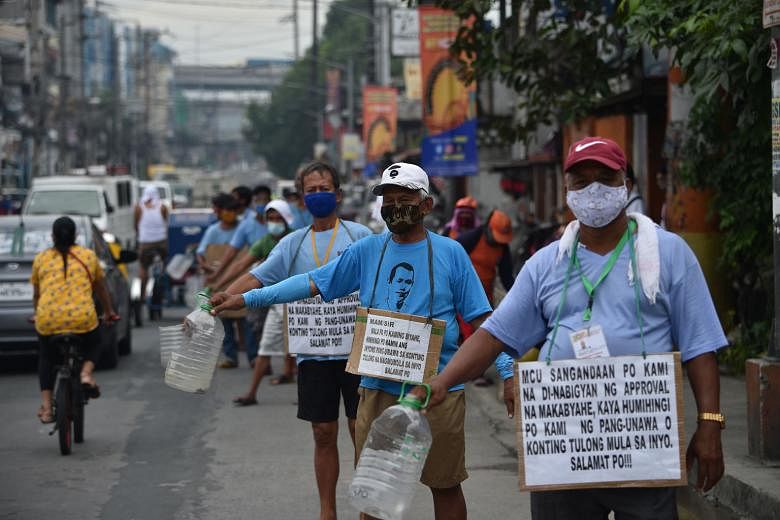 Jeepney drivers appealing to passers-by for money along a road in Manila last Wednesday. PHOTO: AGENCE FRANCE-PRESSE