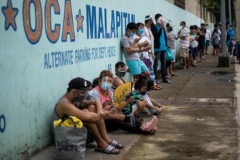 Filipinos waiting to get tested for Covid-19 at a government facility in Metro Manila yesterday. Presidential spokesman Harry Roque said the government will employ pooled testing, and that contact tracers will make house calls, so that more asymptoma