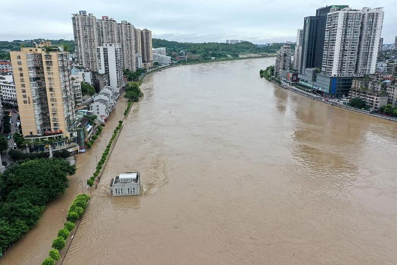 A swollen Tuojiang River yesterday, following heavy rain in south-western Sichuan province. Heavy rain lashed 27 out of 31 of the country's provinces since June this year. PHOTO: AGENCE FRANCE-PRESSE