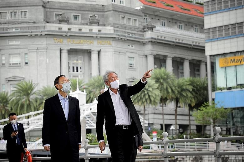 Senior Minister Teo Chee Hean taking a stroll with Mr Yang Jiechi (left) along the Singapore River yesterday. Both countries need to work together more closely to strengthen cooperation in a rules-based international order, and to secure the well-bei