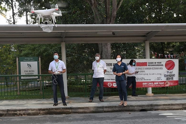 Senior Minister of State for Communications and Information Sim Ann, who is an MP for Holland-Bukit Timah GRC, observing an NEA team operating a drone to detect the presence of stagnant water that may lead to mosquito breeding. The NEA has been deplo