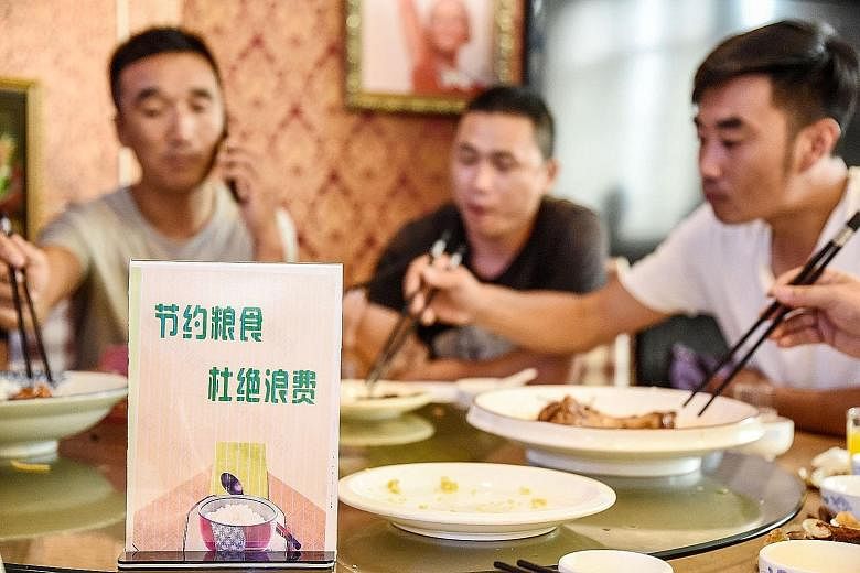 A sign encouraging people not to waste food displayed at a restaurant in Handan, Hebei province, last week. The average Chinese diner throws away 93g of food per meal when eating out, according to a study. This is about 11.7 per cent of his meal. PHO