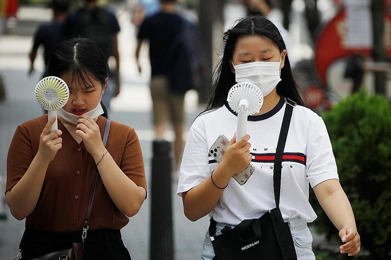 Residents using portable fans to cool down while out on the streets of Seoul amid summer. The Korea Centres for Disease Control and Prevention reported 288 new cases in South Korea as of midnight on Wednesday, marking a week of triple-digit daily inc