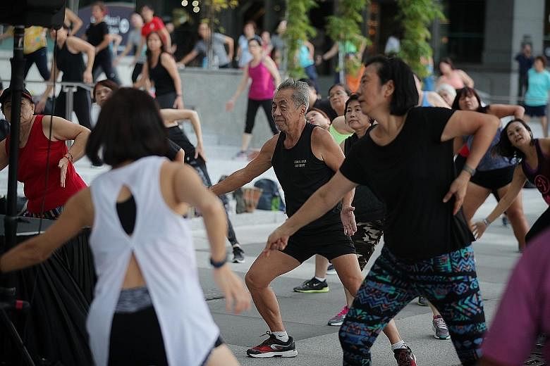 A mass exercise session being conducted in Boat Quay last year. Exercise classes conducted by instructors will now be allowed to take place at more open spaces, but with safe management measures in place.