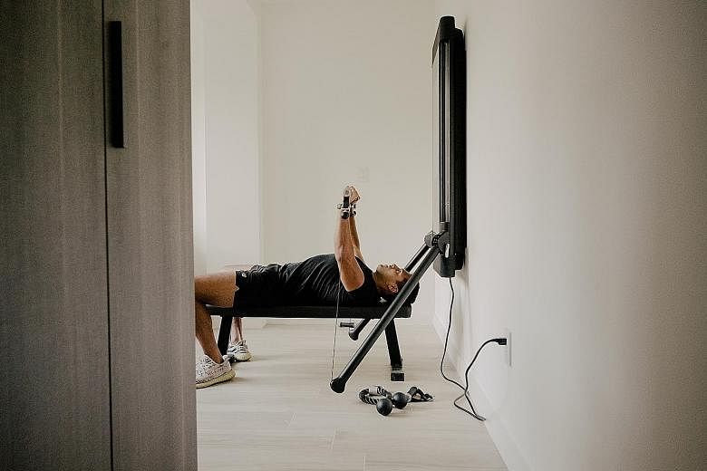 Amay Sheth using his Tonal at home in New York. Three companies - Tonal, Tempo and Forme Life - are competing to supplant cheap dumbbells with four figure-priced smart machines for strength training. Sheth is obsessed with constantly smashing his str