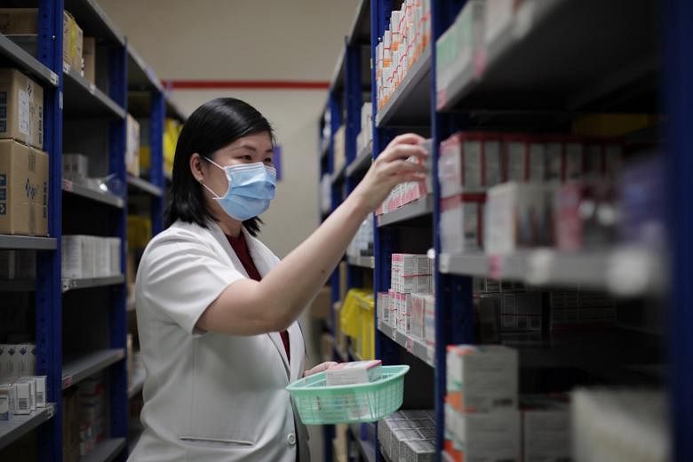 Principal pharmacist Chong Yi San, 41, getting the medications for outpatients at TTSH's pharmacy.