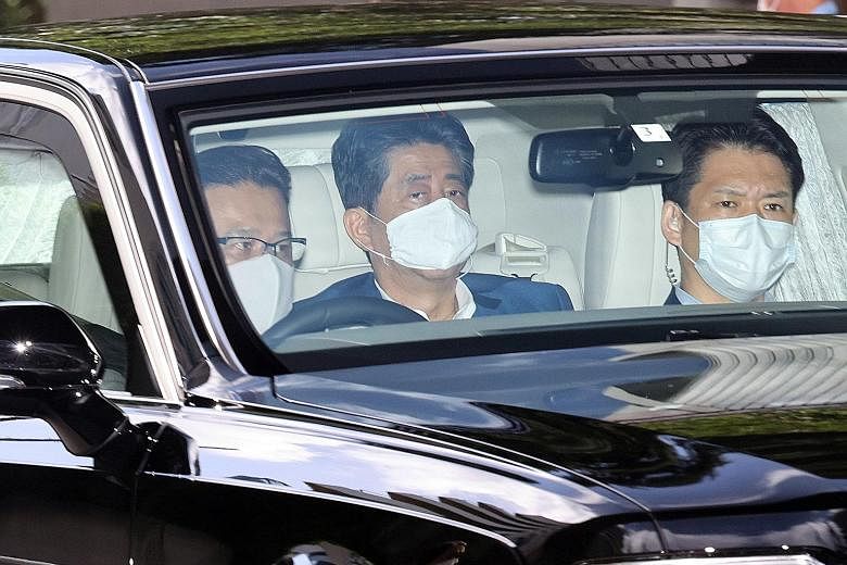 Japanese Prime Minister Shinzo Abe (centre) arriving at Keio University Hospital in Tokyo yesterday. PHOTO: EPA-EFE
