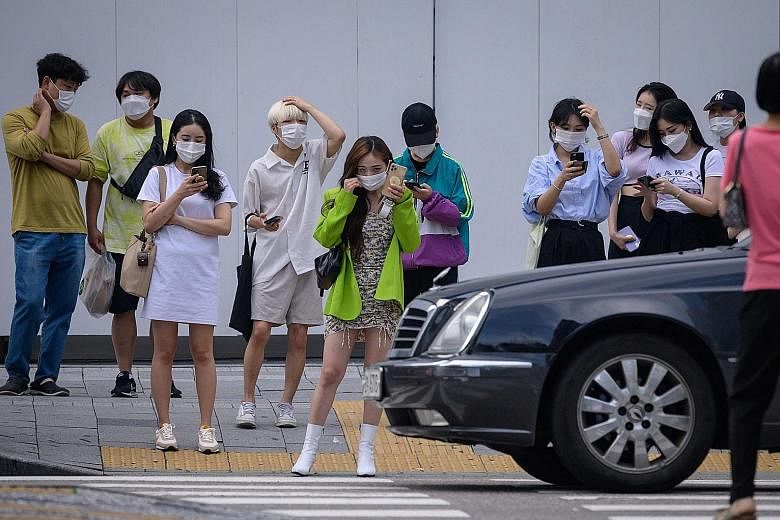 People in Seoul now have to mask up both indoors and outdoors under a new order the South Korean capital has issued for the first time. It is battling a surge in coronavirus cases, with more than a week of triple-digit daily increases. PHOTO: AGENCE 