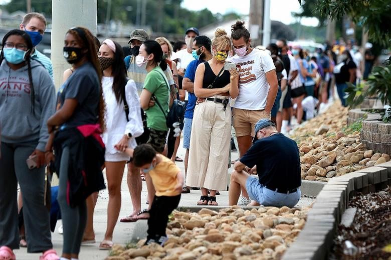 People queueing to enter a store in New Orleans, Louisiana, on Sunday to pick up supplies in preparation for the storms. Flooding in the streets of Santo Domingo, the Dominican Republic, caused houses to collapse on Sunday as Tropical Storm Laura bat
