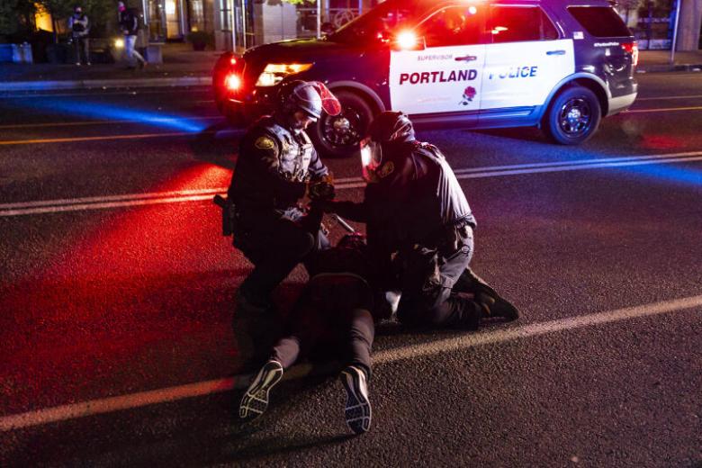 Portland police make multiple arrests, declaring riot as protesters