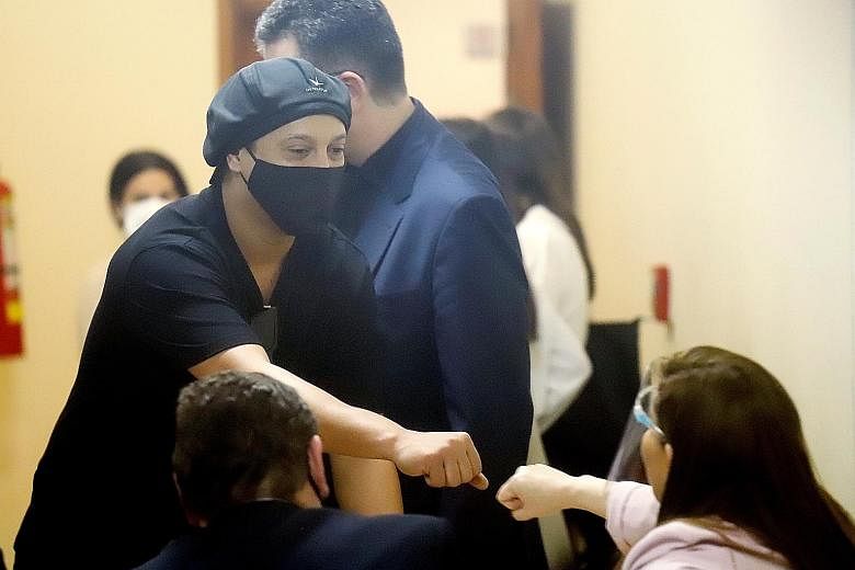 Former Brazil footballer Ronaldinho fist bumps prosecutor Alicia Sapriza after a hearing at the Justice Palace in Asuncion, Paraguay.