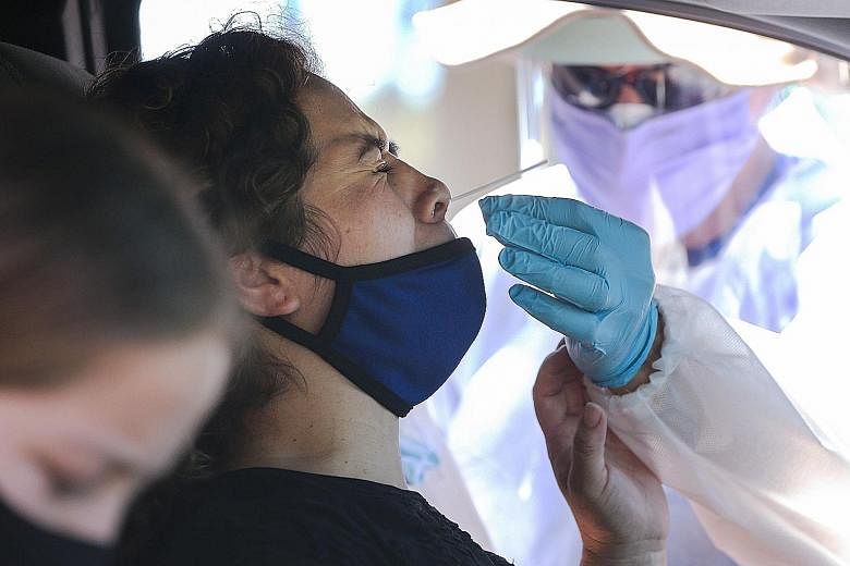 A motorist undergoing a Covid-19 nasal swab test at a drive-in testing centre in Los Angeles earlier this month.