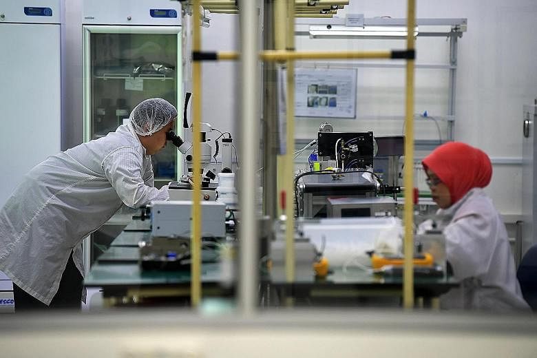 Workers at a medical technology facility last year. The medical technology segment fell 10.1 per cent in July from the same month last year, while pharmaceuticals fell 30.5 per cent due to lower output in biological products and a different mix of ac