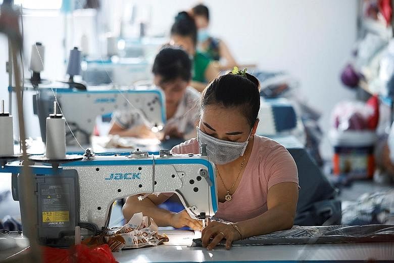 Labourers working at a Hanoi factory which makes blankets, pillows and mattresses for the local market, in June. With garment companies seeing orders slashed and other sectors hit with sudden export declines, Vietnam's workers are enduring the downsi