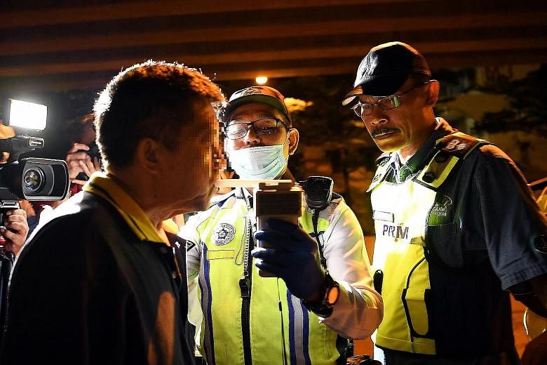 Head of Selangor Traffic Investigation and Enforcement Department, Superintendent Azman Shariat (right), observing a breathalyser test around the Ampang area in Selangor last month. Malaysia's Road Transport (Amendment) Bill 2020 was passed on Wednes