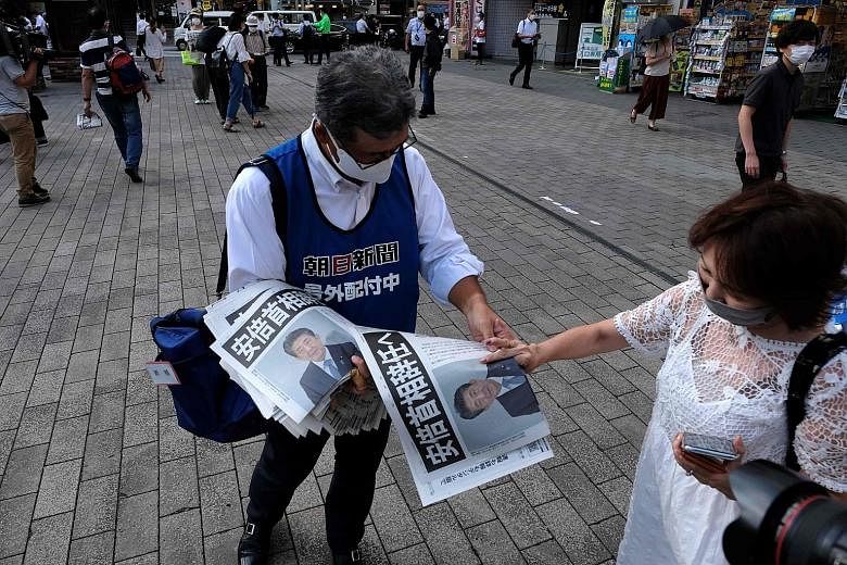 An extra edition of a local newspaper being given out in Tokyo yesterday to inform the Japanese public of Prime Minister Shinzo Abe's resignation. PHOTO: AGENCE FRANCE-PRESSE