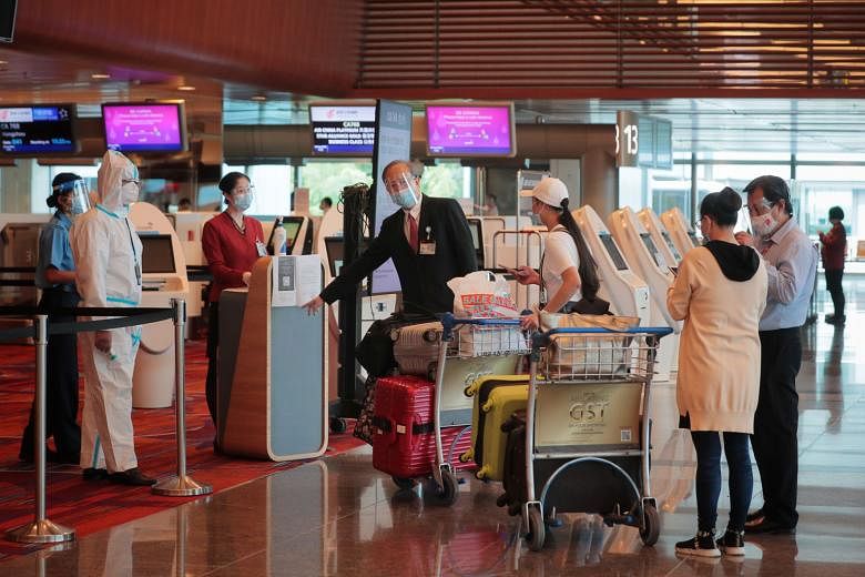Ms Tang Yun (in cap) and Ms Zhang Yan (right) checking in at Changi Airport yesterday. They were among the first batch of China-bound passengers leaving Changi Airport yesterday after stricter rules were imposed.