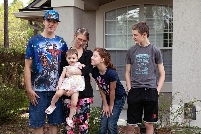Mr Jared Strickland and his wife Karla Dennington with their children, Gracey, 17 months, Serenity, 12, and Riley, 14, at his parents' home in Florida where they live. After the pandemic hit, Mr Strickland was laid off. To keep food on the table, the