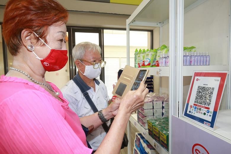 Mr Wee Yoke Eng, 87, and his wife, Madam Chu Sew Kiak, 75, practising how to make digital payments at a makeshift "minimart" at Teck Ghee Community Club. PHOTO: LIANHE ZAOBAO