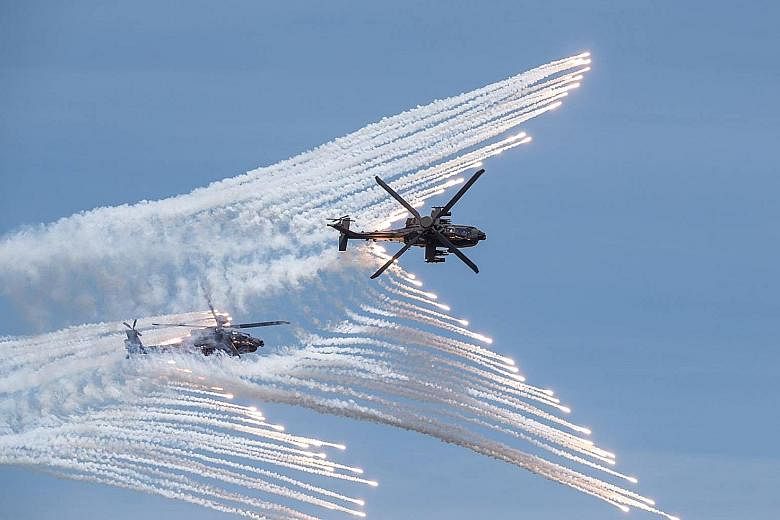 Rockets (above) being launched from a domestically manufactured multiple rocket system and two US-made AH-64E attack helicopters (left) releasing flares during a Taiwanese military drill in Taichung last month. The exercises aimed to demonstrate how 