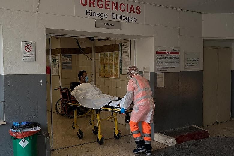 A suspected Covid-19 patient being wheeled into the emergency room of a hospital in Malaga, Spain, on Sunday. PHOTO: NYTIMES