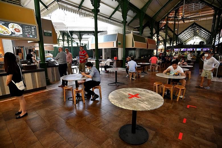 Diners at Lau Pa Sat food centre on Tuesday. Prime Minister Lee Hsien Loong, citing a recent survey by The Straits Times showing almost half of the respondents being tired of pandemic safety measures such as having to wear a mask, warned that the cor