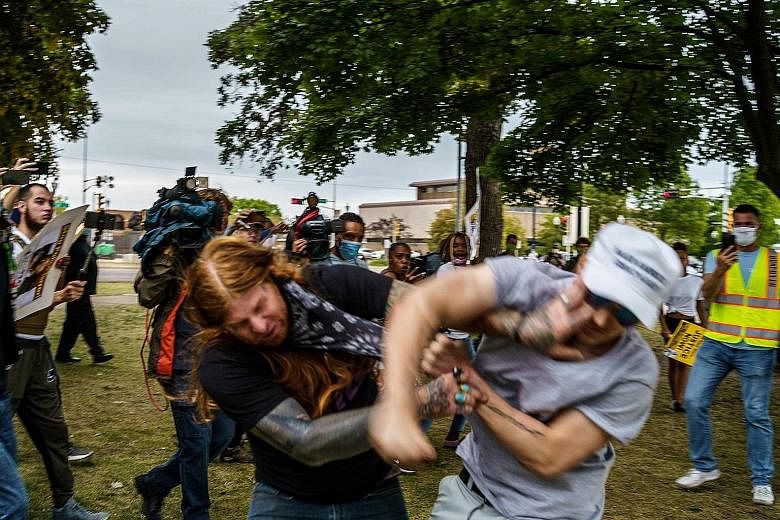 A protester (left) scuffling with a Trump supporter on Tuesday in Kenosha, Wisconsin, where tensions run high amid ongoing unrest in the city triggered by the police shooting of a black man, Mr Jacob Blake, on Aug 23.