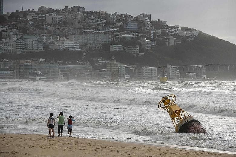 A buoy rocking during a heavy swell brought by Typhoon Maysak at Haeundae beach in Busan, South Korea, yesterday. The city bore the brunt of the storm's 170kmh winds, which shattered windows and caused one death. Another man was found dead, believed 