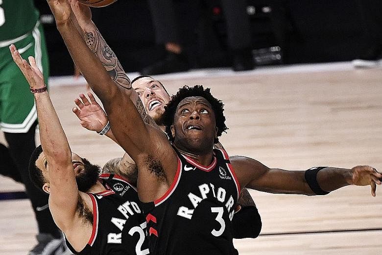 Toronto's O.G. Anunoby fighting for possession against Boston on Thursday in Florida. His buzzer beater meant the Raptors edged out the Celtics 104-103 and cut the deficit to 2-1 in their Eastern Conference semi-final series. PHOTO: AGENCE FRANCE-PRE