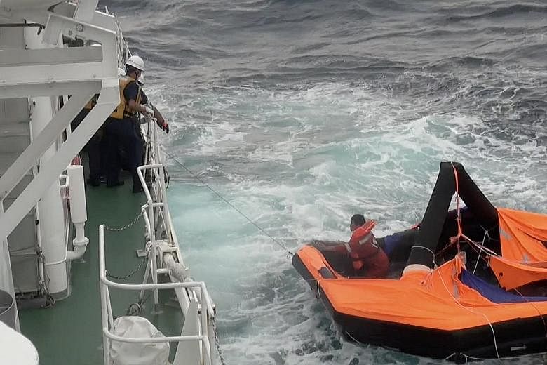 Filipino Jay-nel Rosals being rescued by Japan Coast Guard crew on Friday. The crewman from the Gulf Livestock 1 vessel was found on a life raft waving for help 2km off Kodakarajima, a small island in Japan's southern Kagoshima prefecture. PHOTO: