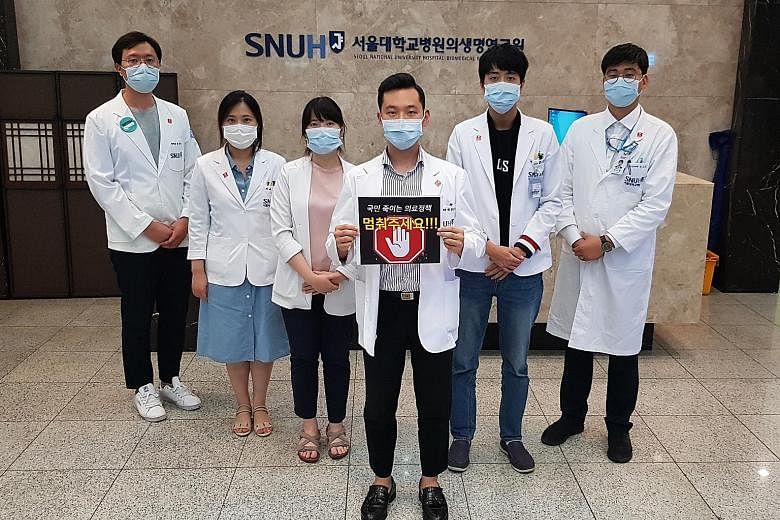 A group of resident doctors at Seoul National University Hospital who joined a strike against the government's medical reform plan, holding a sign that says "stop medical policies that kill people". ST PHOTO: CHANG MAY CHOON