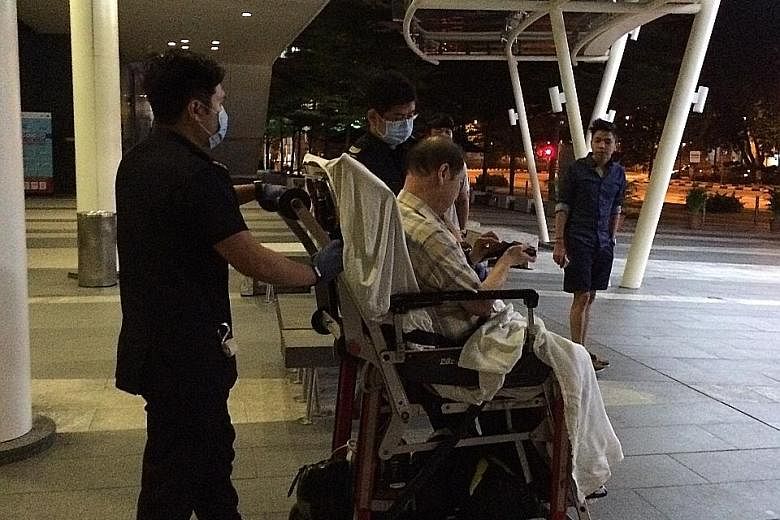 Mr Ng Tee Kian being taken for treatment after he slipped and fell outside a retail unit at Fusionopolis One in 2016. He sued the facilities manager for the building for negligence, but the court stand-off was averted when the defendant accepted 60 p