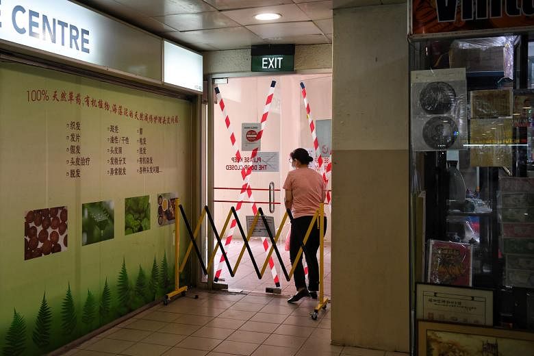 A woman skirting a movable barricade to access the doors for entry to and exit from the third floor of People's Park Centre last week. The mall was one of 16 found by the Singapore Civil Defence Force to have breached fire safety requirements by padl