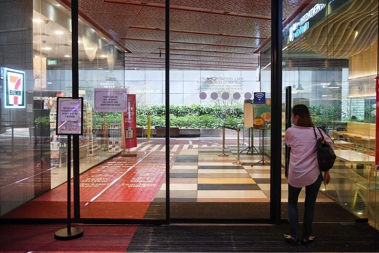 A woman skirting a movable barricade to access the doors for entry to and exit from the third floor of People's Park Centre last week. The mall was one of 16 found by the Singapore Civil Defence Force to have breached fire safety requirements by padl